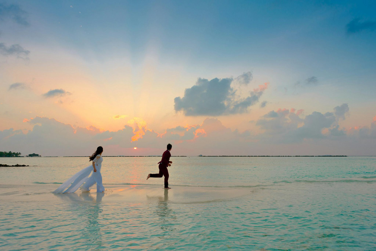 Dramatic beach wedding portrait showing water reflection at a Thailand island resort